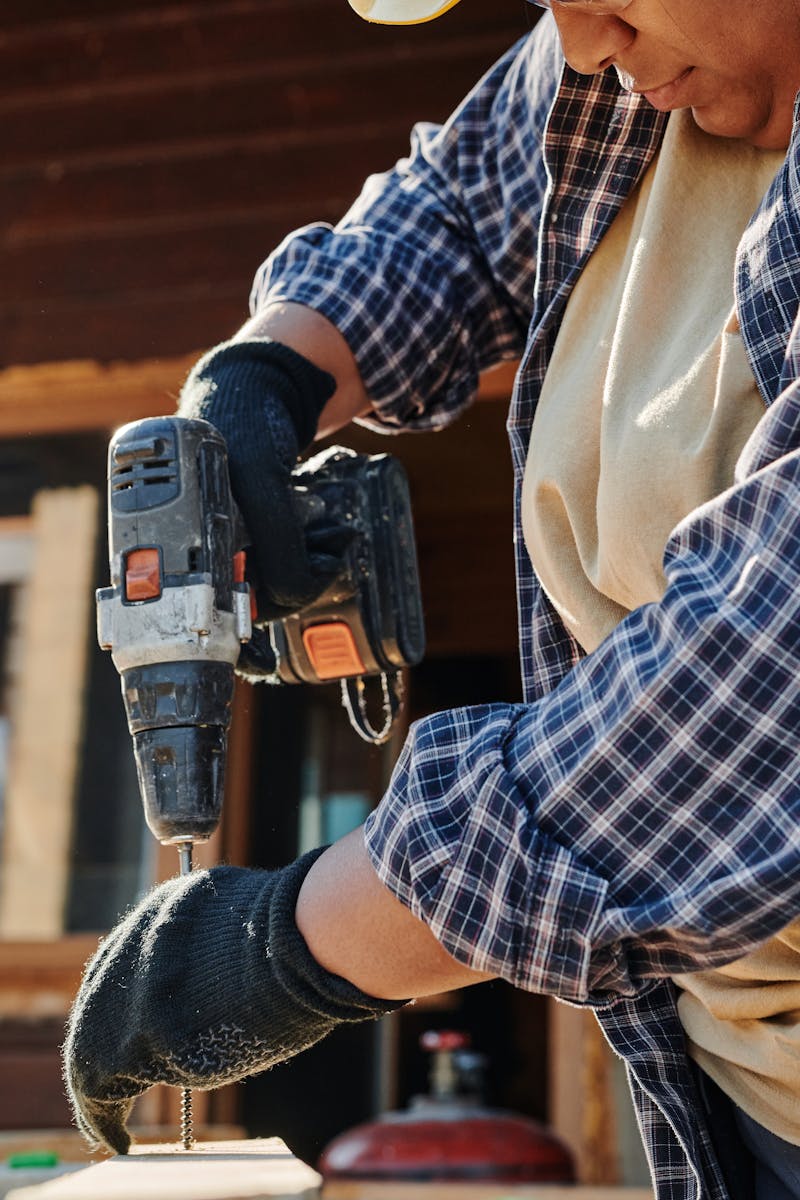 A Person in Plaid Shirt Using a Power Tool, wohnen und leben,